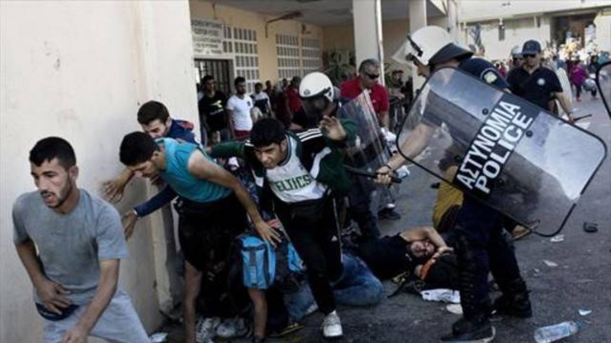 La policía reprime a refugiados en el puerto de Mitilene, ayer.-Foto: AFP / ANGELOS TZORTZINIS