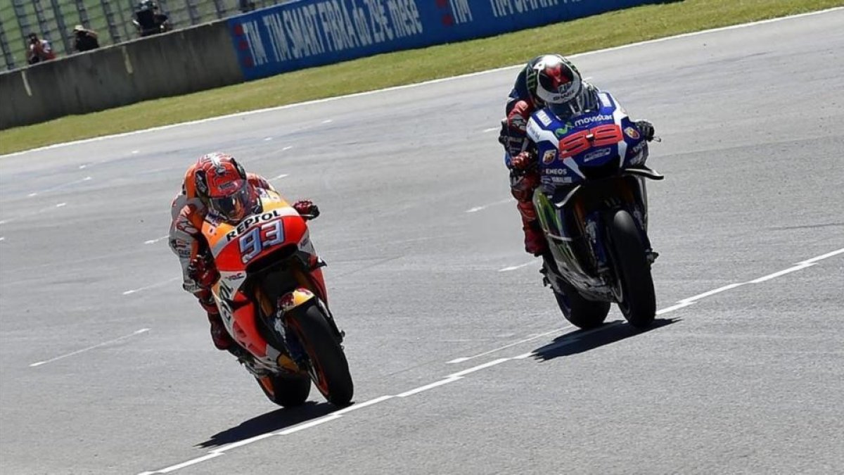 Jorge Lorenzo, a la derecha, rebasa en la misma línea de meta a Marc Márquez en la carrera de Moto GP del circuito de Mugello-EFE / ETTORE FERRARI