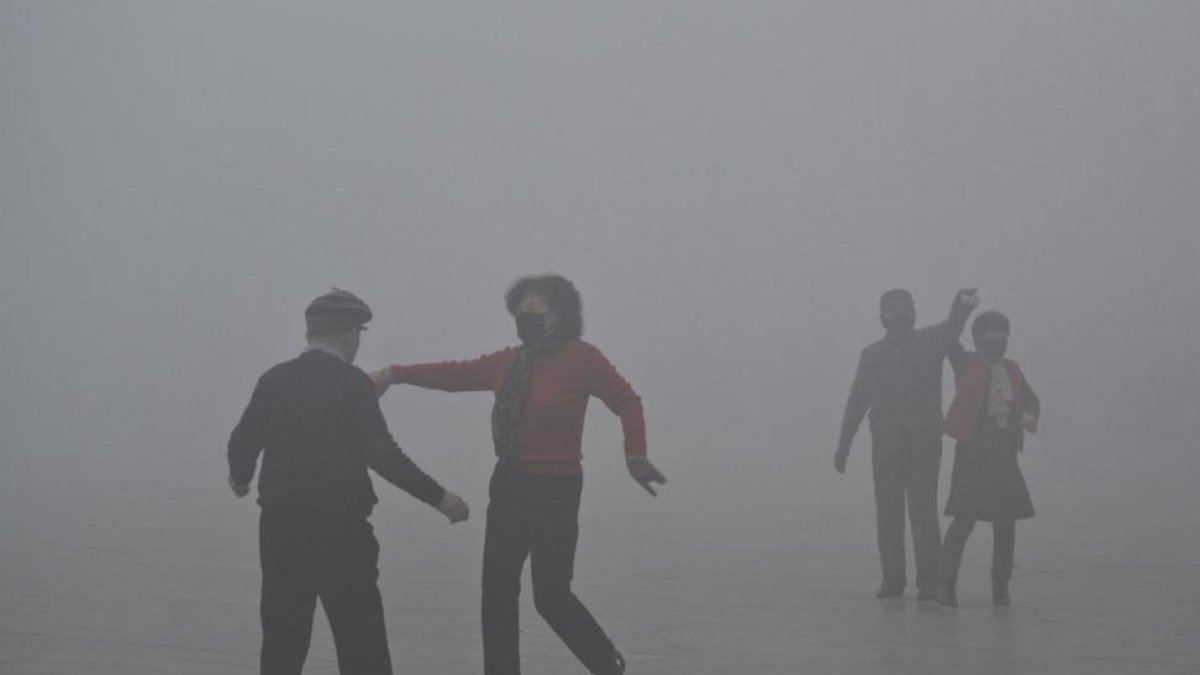 Personas con mascarillas bailan en un parque de Fuyang, el martes 3 de enero.-AP
