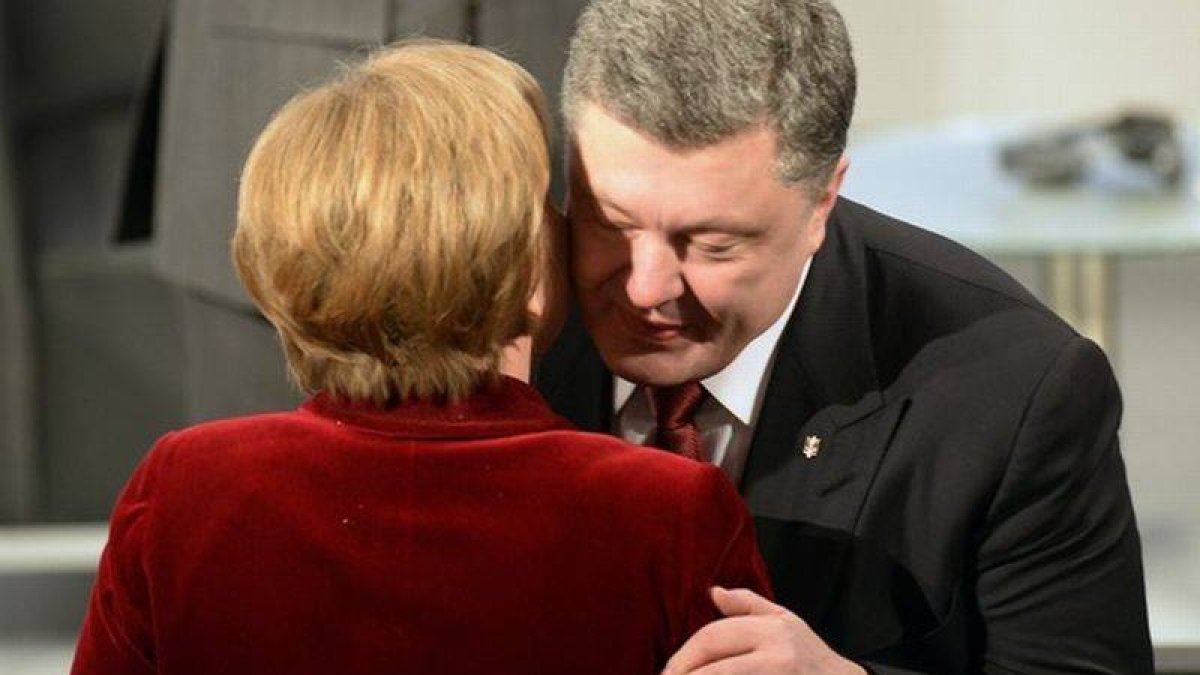 La cancillera Angela Merkel y el presidente de Ucrania, Petro Poroshenko, se saludan en Múnich.-Foto: THOMAS KIENZLE / AFP