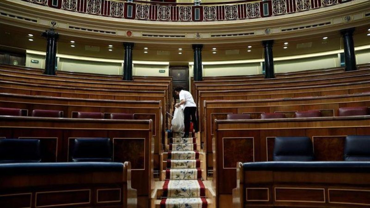 Labores de limpieza en el hemiciclo del Congreso de los Diputados, tras quedarse vacío el pasado 28 de febrero.-CHEMA MOYA (EFE)