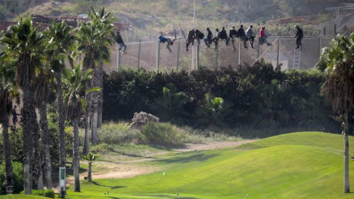 Dos jugadoras en un campo de golf, a pocos metros de la valla de la frontera de Melilla.-Foto: JOSÉ PALAZÓN