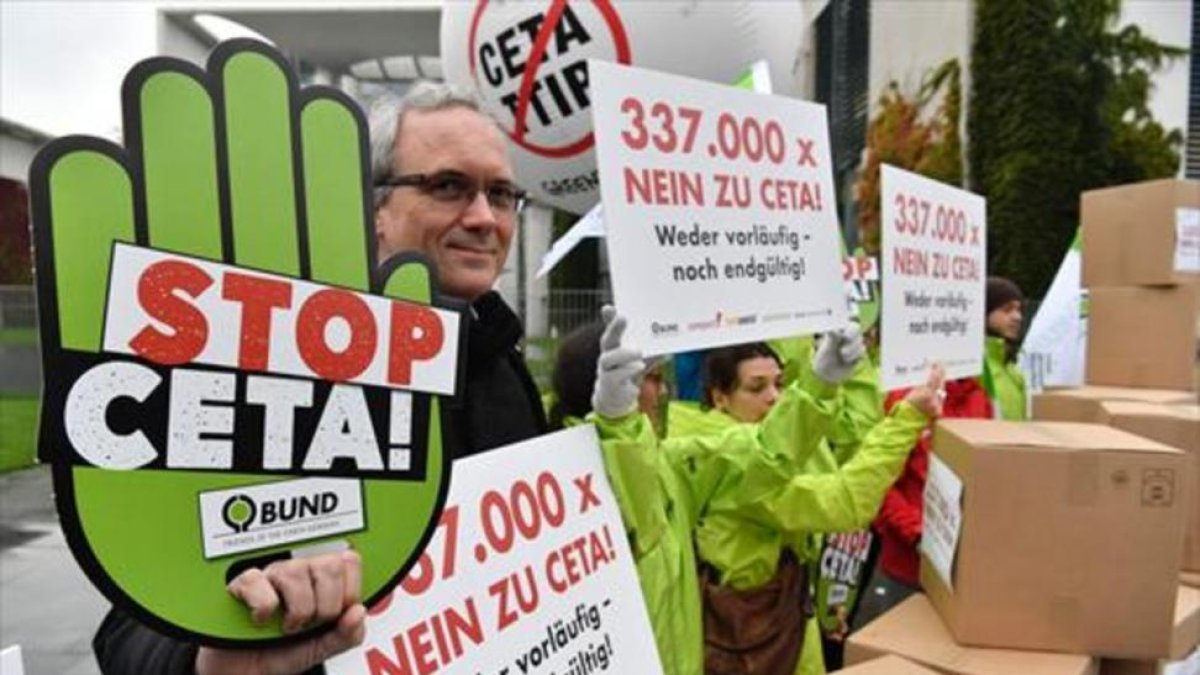 Ciudadanos contrarios al CETA y el TTIP se manifiestaron delante de la Cancillería alemana, en Berlín.-AFP / JOHN MACDOUGALL