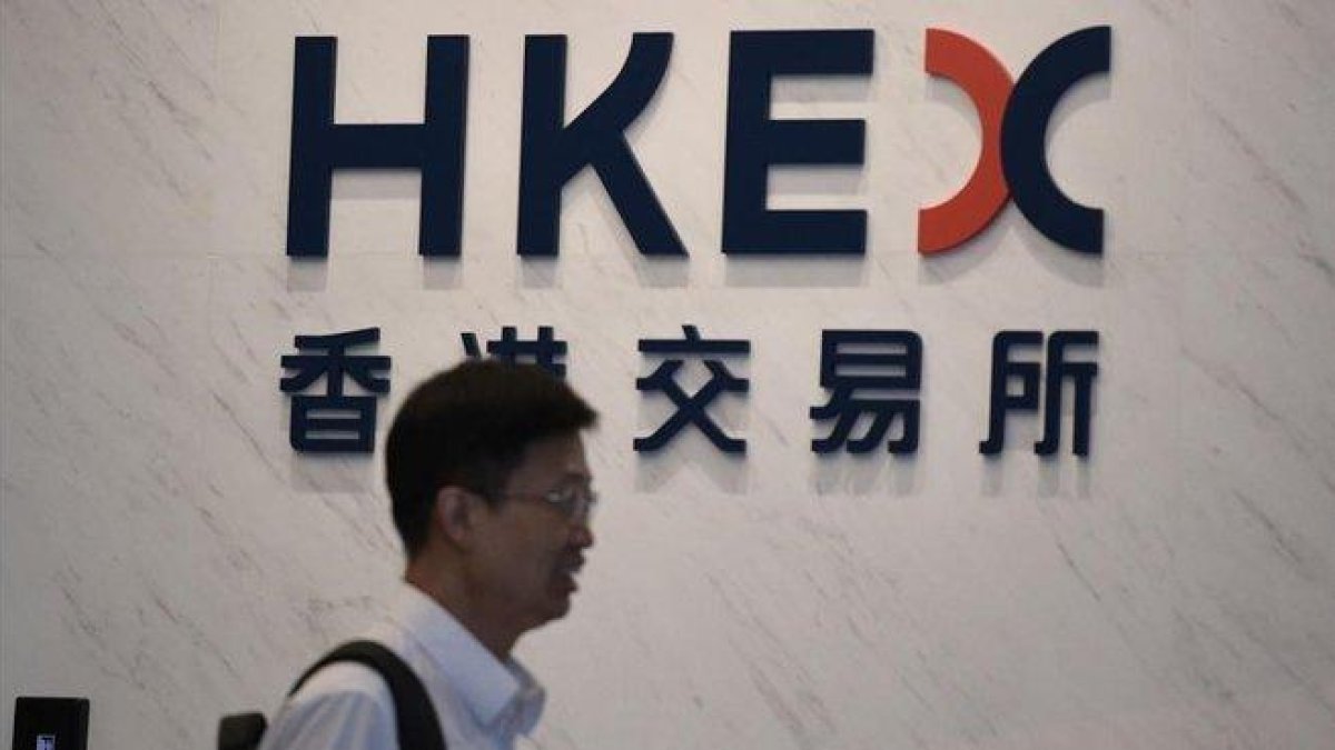 Un hombre pasa frente a la sede de Hong Kong Exchanges and Clearing (HKEX).-AFP / NICOLAS ASFOURI