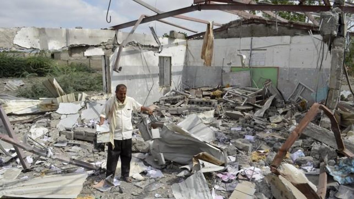 Un hombre intenta rescatar algunas pertenencias de un edificio en Bajil (Yemen) destruido por la coalición árabe.-ABDULJABBAR ZEYAD / REUTERS