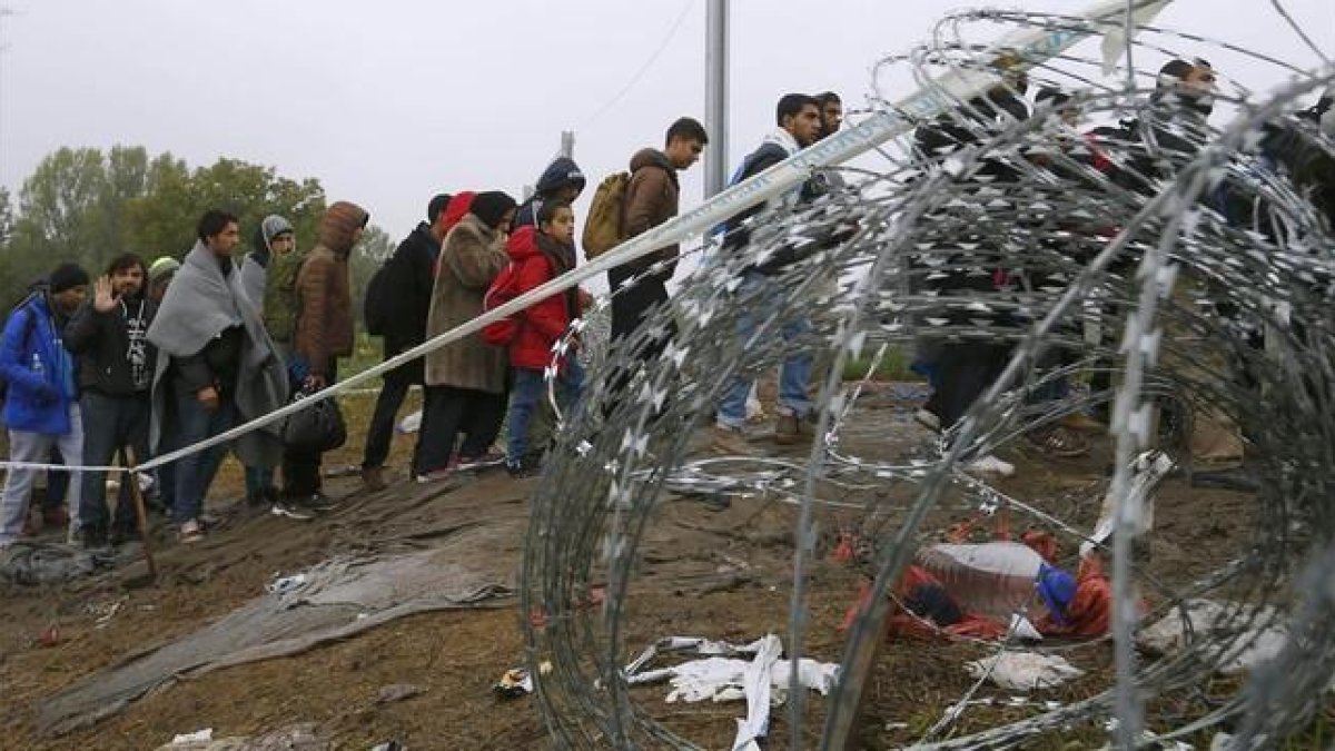 Refugiados cruzando la frontera entre Hungría y Croacia después de llegar en tren a la ciudad croata de Botovo.-LASZLO BALOGH / REUTERS