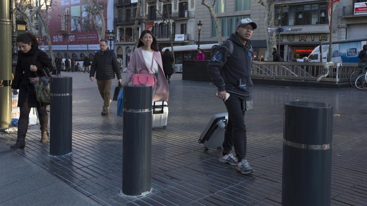 Bolardos situados en la entrada a la Rambla después de los atentados.-ALBERT BERTRAN