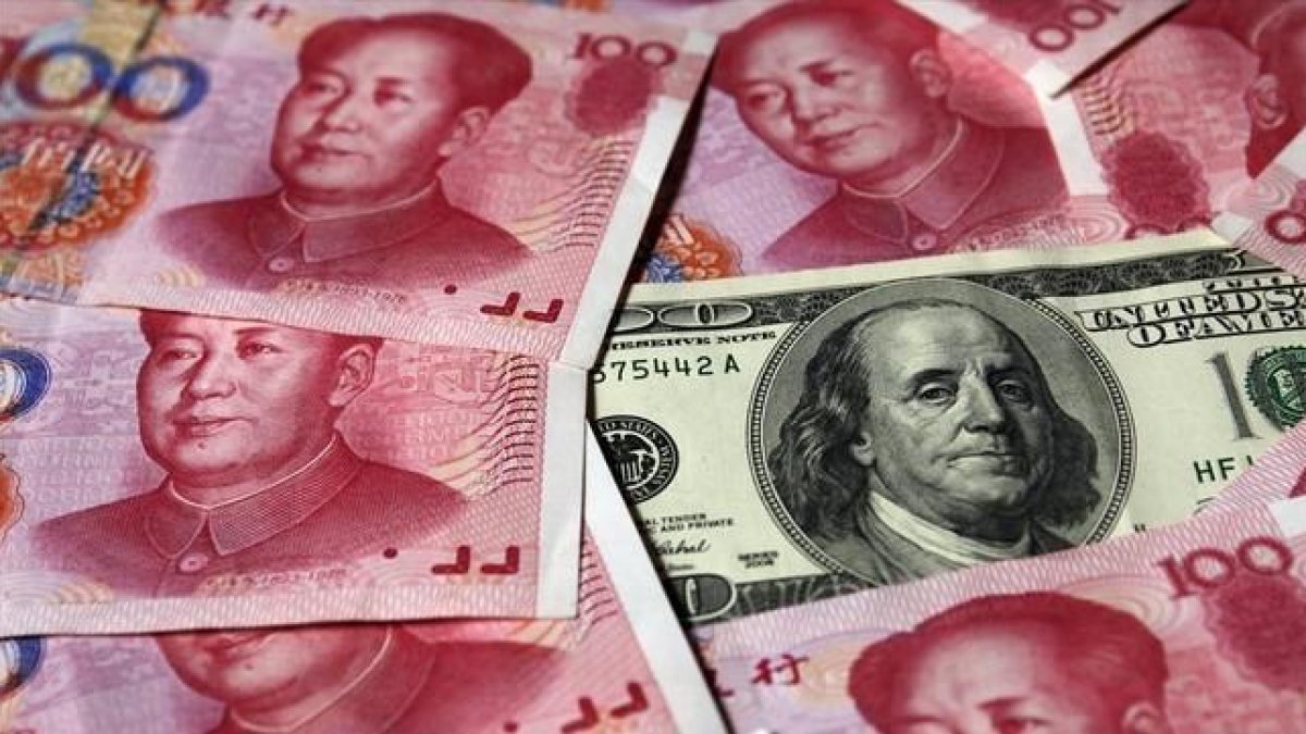 Billetes de yuan junto a un dólar-REUTERS / PETAR KUJUNDZIC