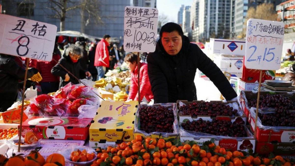 Un vendedor de fruta en un mercado de Pekín.-WU HONG / EFE