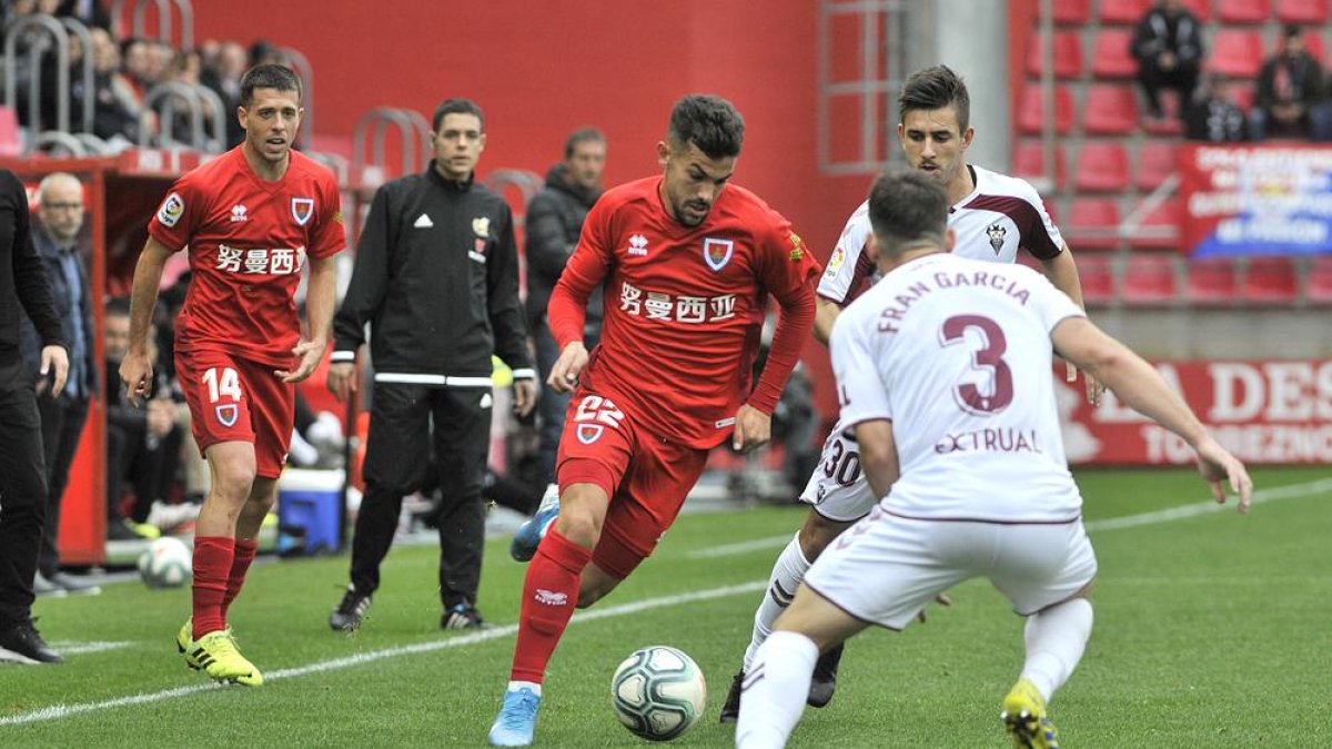 Curro Sánchez intenta sortear a Fran García y Manu Fuster durante el partido ante el Albacete.-VALENTÍN GUISANDE