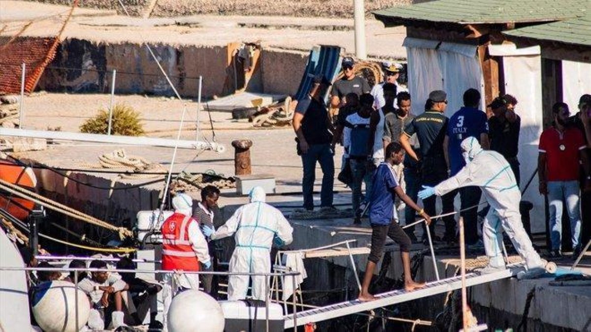 Menores no acompañados desembarcan en el puerto de Lampedusa procedentes del ’Open Arms’.-AFP / ALESSANDRO SERRANO