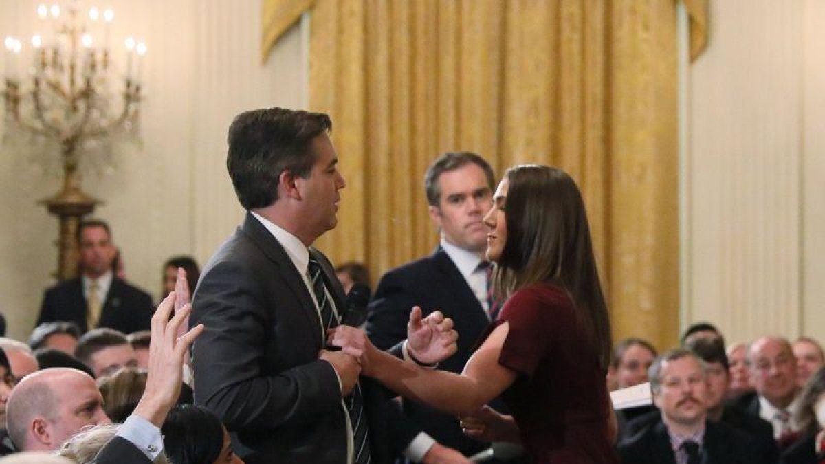 Trabajadores de la Casa Blanca intentan quitar el micrófono al periodista de la CNN.-REUTERS