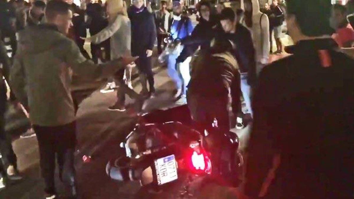 Unos manifestantes tiran a un motorista que no ha querido bajarse de la moto y pretendía continuar su paso, en el paseo de Gracia con la calle Valencia, este miércoles.-GUILLEM SÀNCHEZ