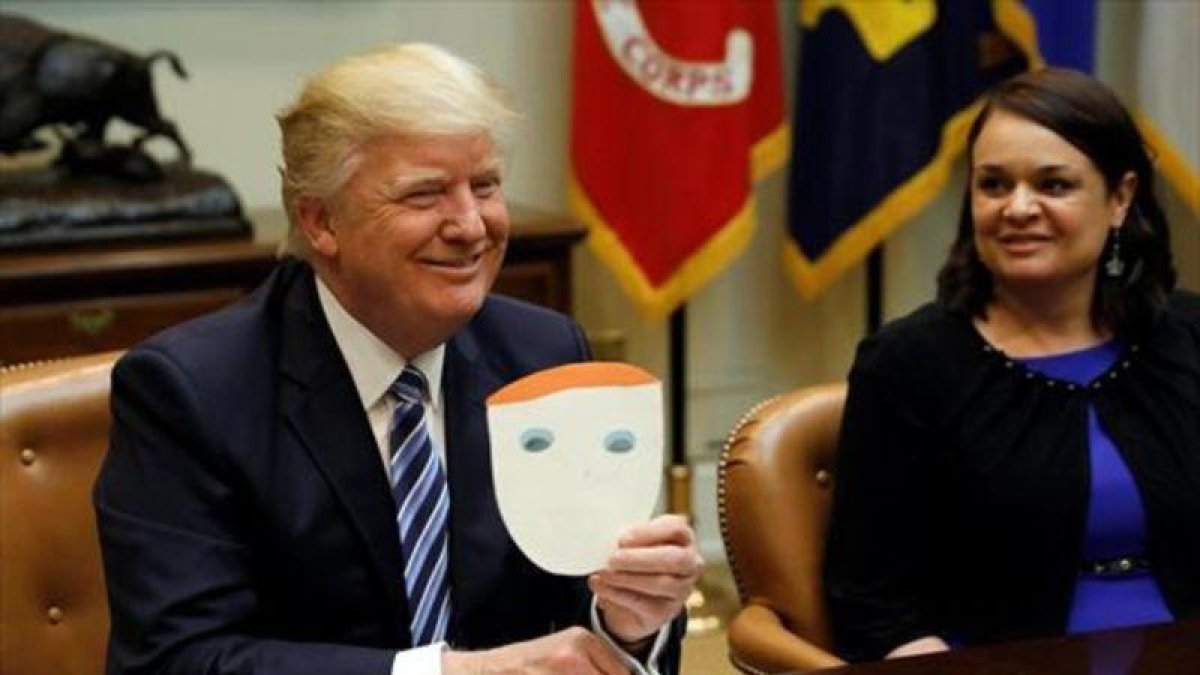 Trump muestra una tarjeta enviada por un niño, en la Casa Blanca.-REUTERS / KEVIN LAMARQUE