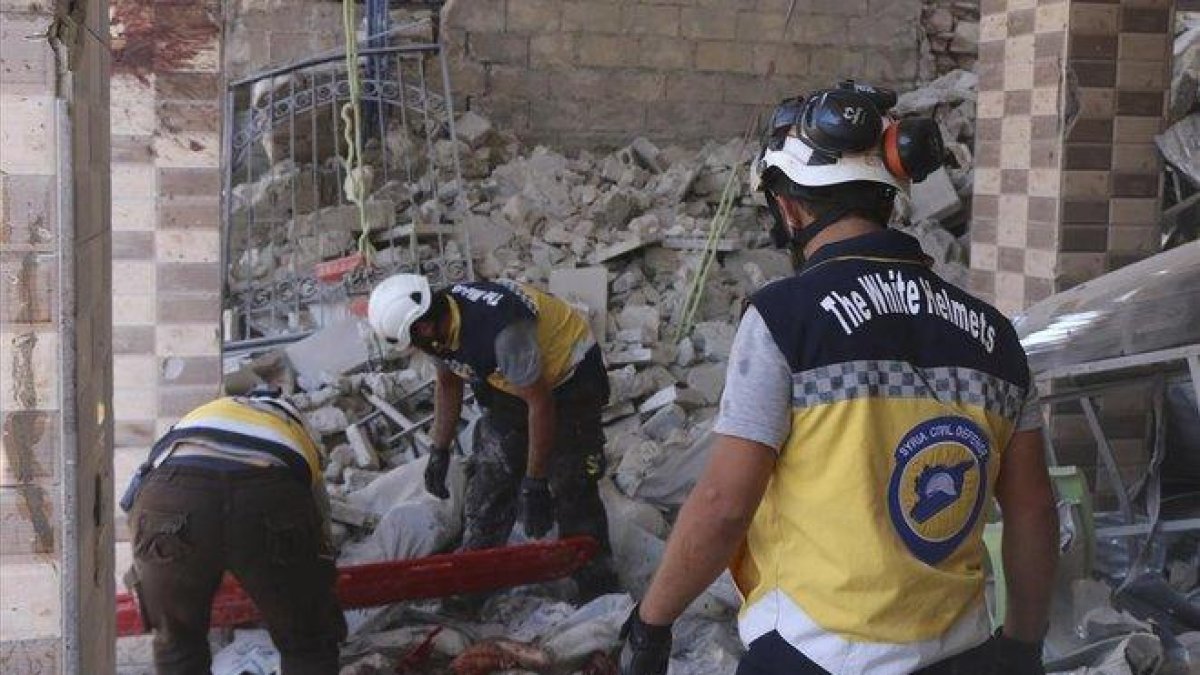 Trabajadores buscan víctimas debajo de los escombros de un edificio destruido que fue golpeado por el gobierno sirio y ataques aéreos rusos en la ciudad norteña de Maaret al-Numan en la provincia de Idlib, Siria, el lunes 22 de julio de 2019.-