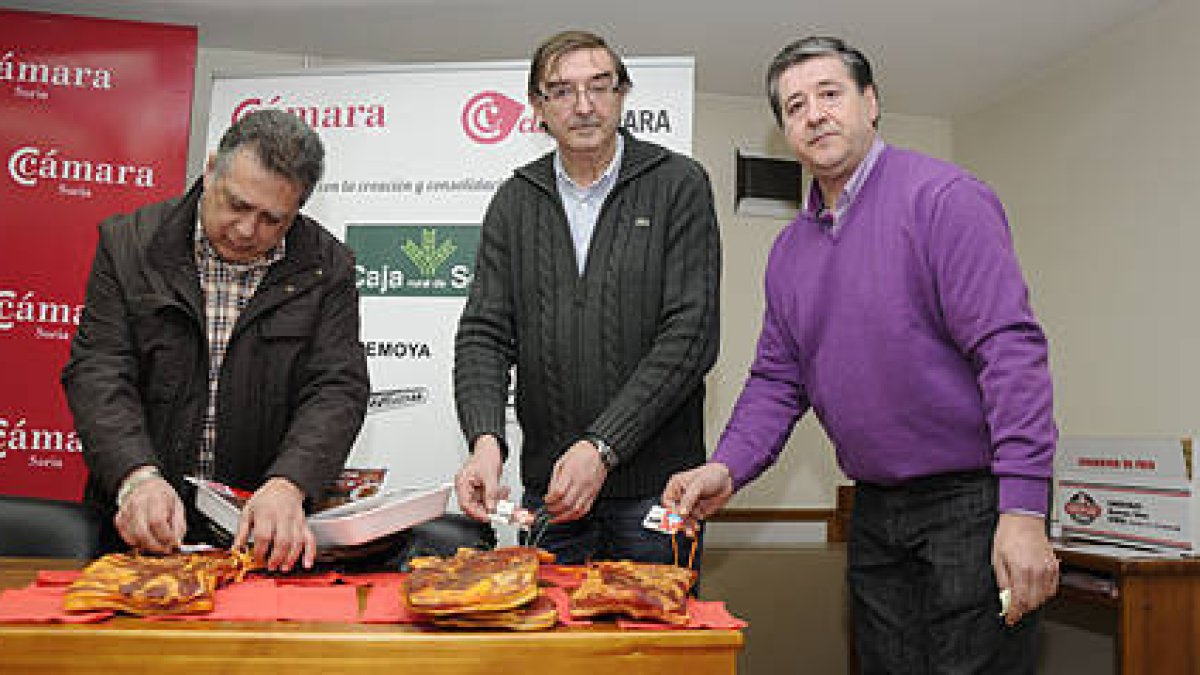 Juan José Jiménez, Samuel Moreno y José Luis Llorente colocan las nuevas etiquetas en pancetas ‘homologadas’. / VALENTÍN GUISANDE-