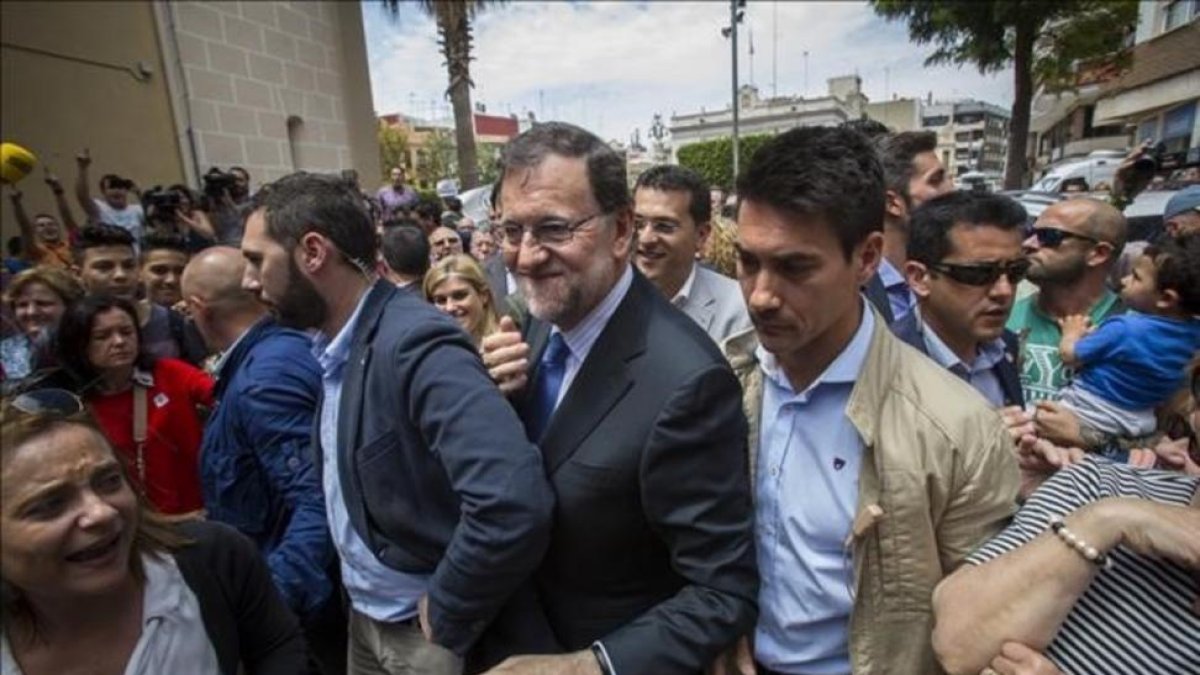 El presidente del Gobierno en funciones, Mariano Rajoy, increpado a su llegada al municipio valenciano de Alfafar.-MIGUEL LORENZO
