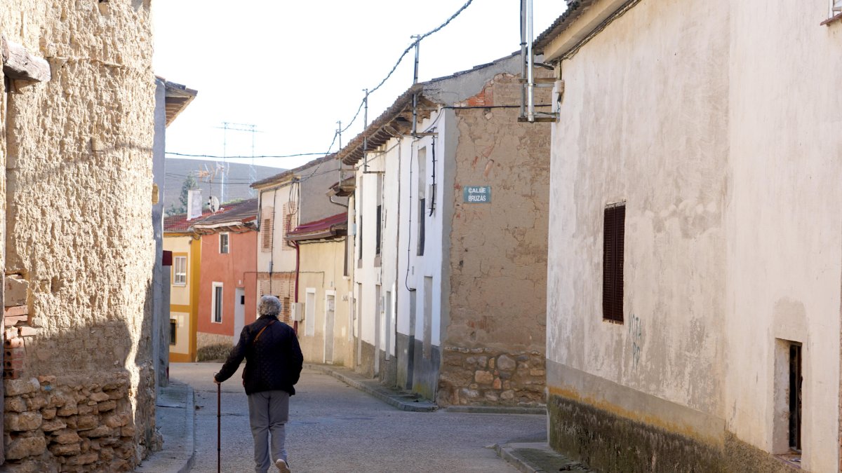 Una mujer camina por la calle de un pueblo de Valladolid.-ICAL