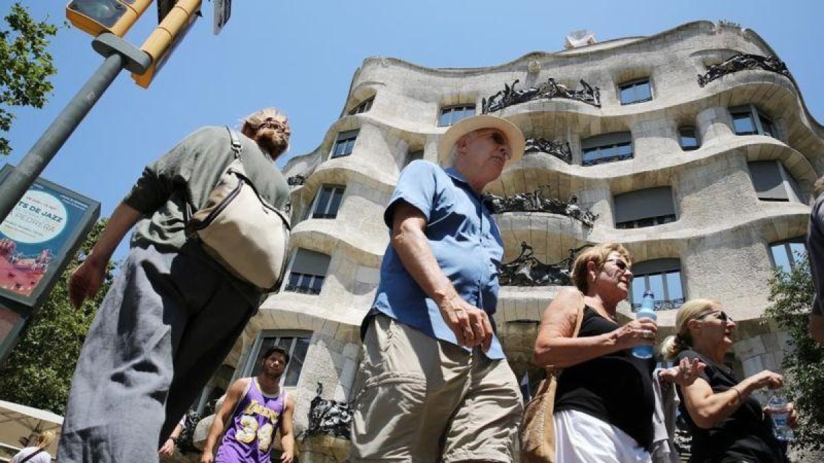 El sector turístico contribuyó a mejorar el crecimiento económico en el 2018. En la foto, turistas ante la Pedrera de Barcelona.-RICARD CUGAT
