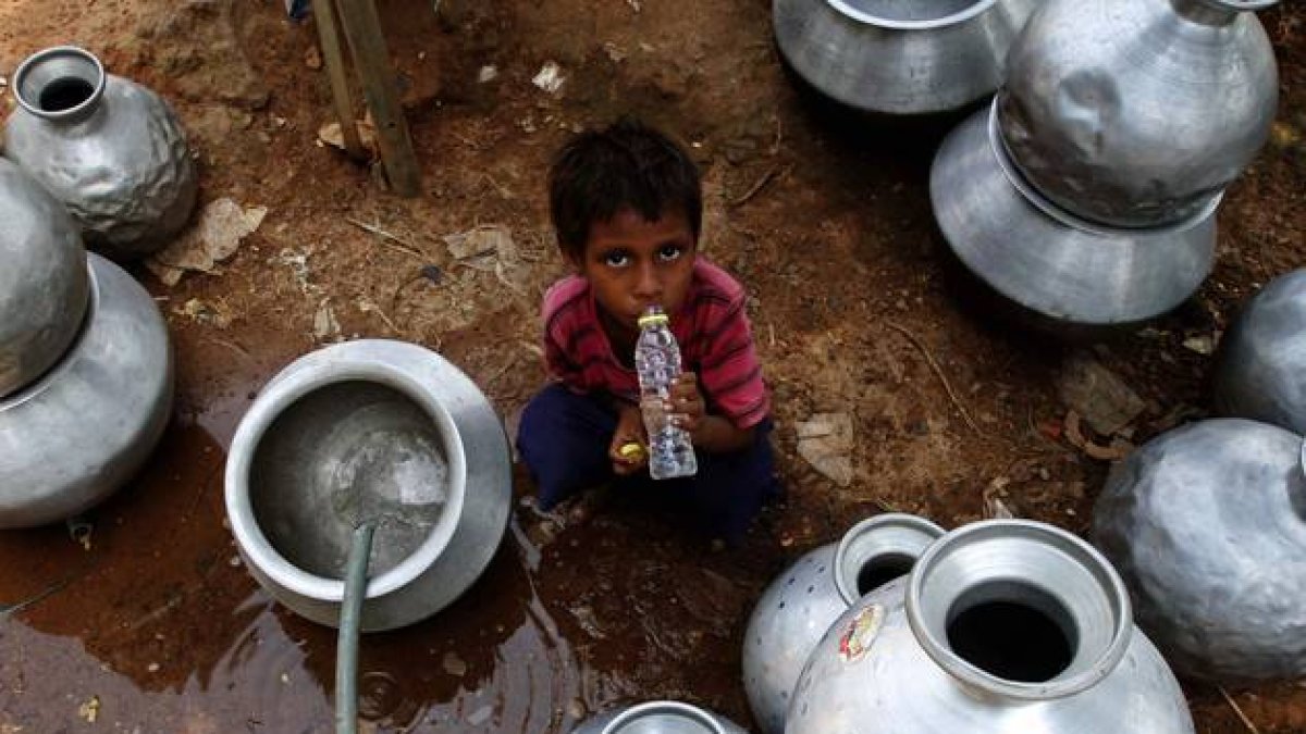 Un niño indio recoge agua en un depósito gubernamental en Bhubaneswar, este sábado.-Foto: AP / BISWARANJAN ROUT