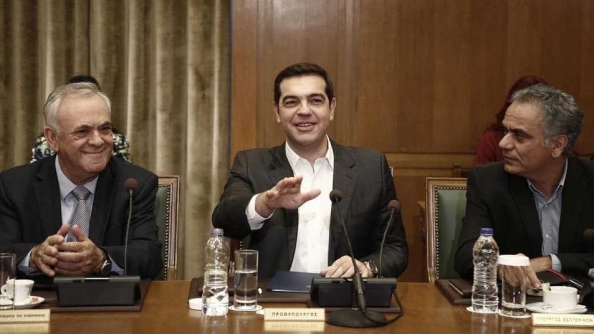 Tsipras (centro) gesticula junto al viceprimer ministro Yiannis Dragasakis (izq) y el ministro de Interior, Panagiotis Skurletis, en el consejo de ministros celebrado en el Parlamento, en Atenas, este domingo.-EFE / YANNIS KOLESIDIS
