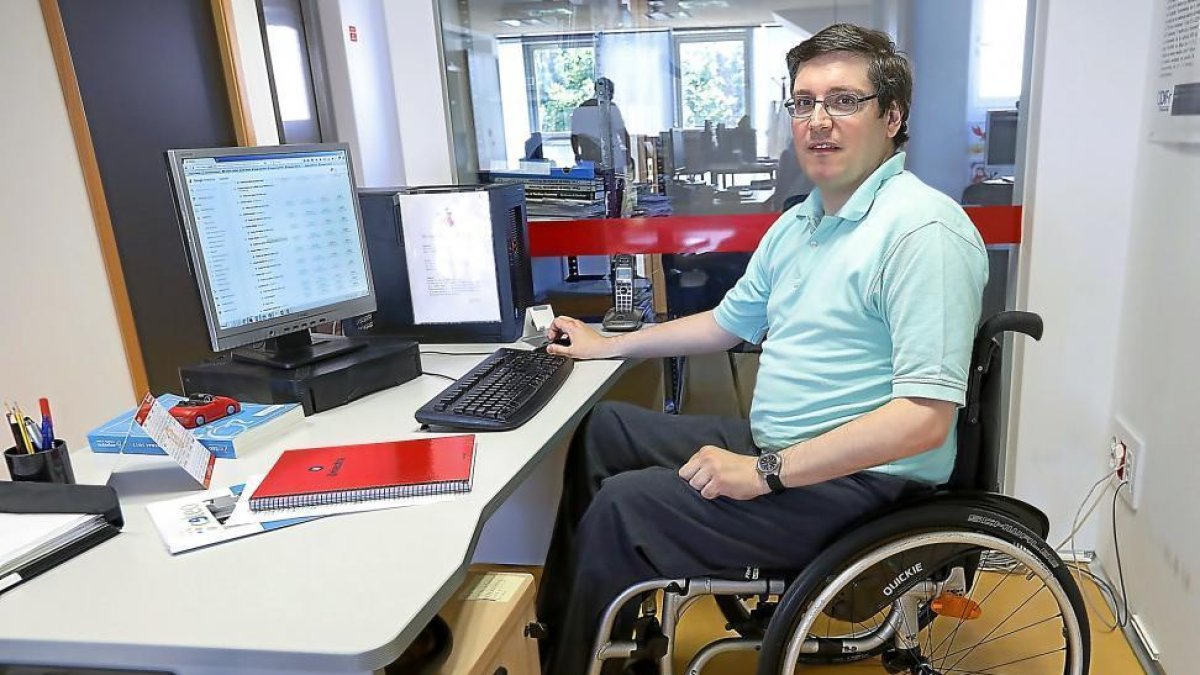 Federico Vallmitjana, a la izquierda, trabajando en la sede de Aspaym en las distintas páginas web de la asociación-J. M. LOSTAU