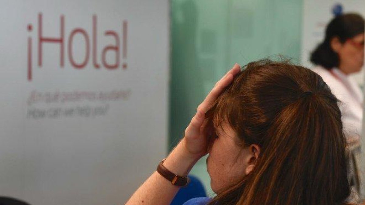 Una pasajera, en el mostrador de atención al cliente del aeropuerto de El Prat.-JORDI COTRINA