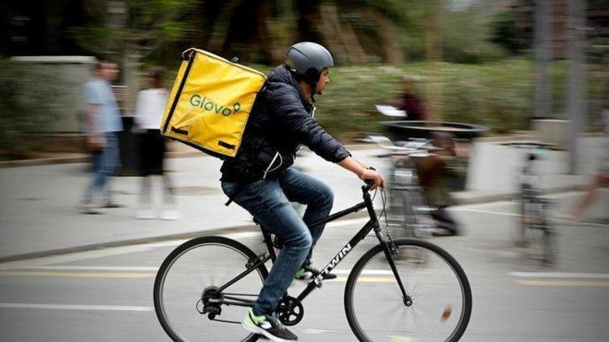 Un repartidor de Glovo pedaleando en Barcelona.-FERRAN NADEU (EL PERIÓDICO)