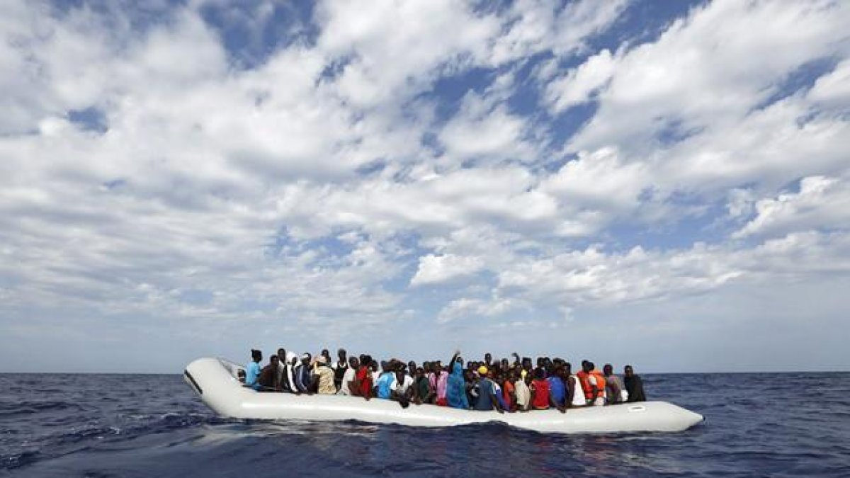 Refugiados a borde de un cayuco frente a la costa de Lampedusa, en Italia.-DARRIN ZAMMIT LUPI / MOAS.EU / EFE