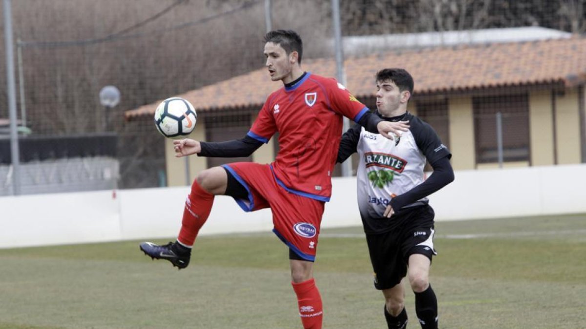 Elgezabal pugna por el balón con un jugador del Tudelano, ayer, en la Ciudad del Fútbol.-LUIS ÁNGEL TEJEDOR