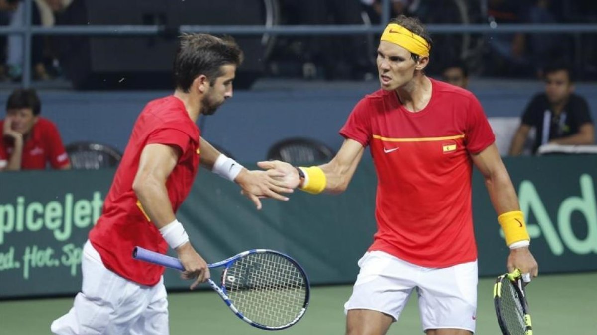 Marc López y Rafael Nadal celebran un punto ganado a los indios Leander Paes y Saketh Myneni durante la eliminatoria de Copa Davis disputada en Nueva Deli.-AP / TSERING TOPGYAL