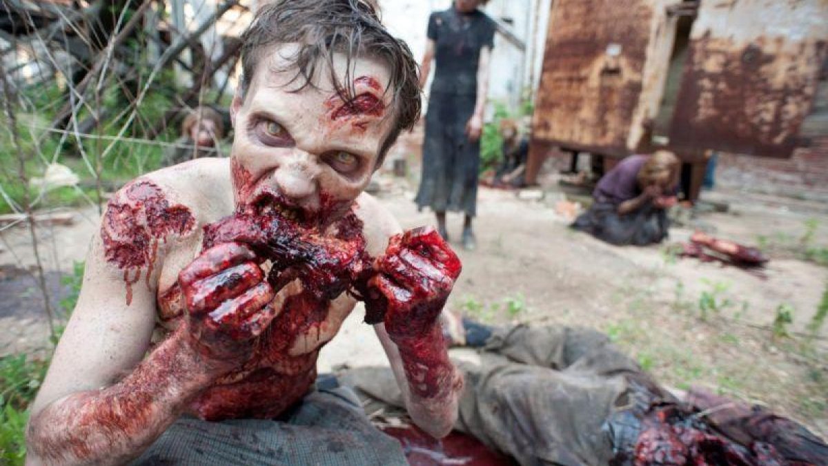 Uno de los zombis de la serie The walking dead, devorando a una de sus víctimas.-EL PERIÓDICO