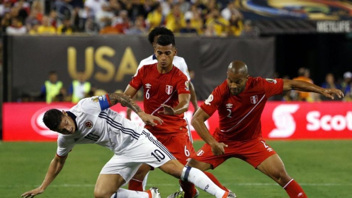 El colombiano James Rodriguez pugna por el balón con los peruanos Alberto Rodriguez y Miguel Trauco.-EFE