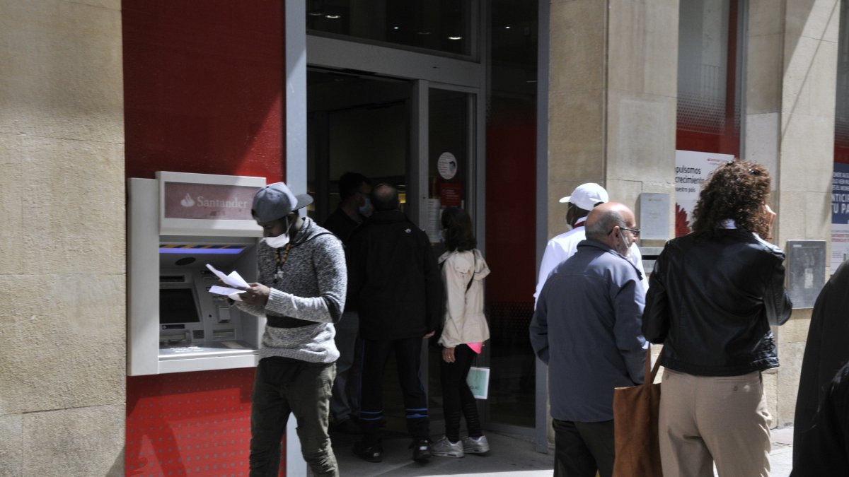 Varias personas aguardan en la puerta de un banco en una imagen de archivo. HDS