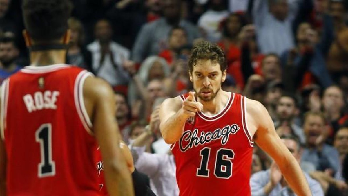 Pau Gasol agradece la asistencia a su compañero Derrick Rose en el duelo ante los Thunders.-AP / JEFF HAYNES