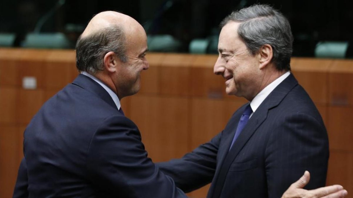 El ministro de Economía, Luis de Guindos, y el presidente del BCE, Mario Draghi, en una imagen de archivo.-FRANCOIS LENOIR / REUTERS