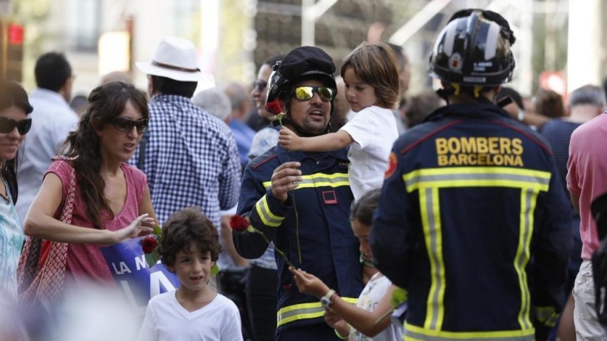 Un bombero con un niño en brazos durante la marcha-ALBERT BERTRÁN