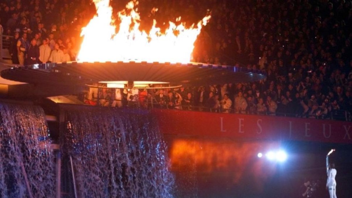 La atleta australiana Cathy Freeman observa el pebetero recién encendido, que se quedó anclado varios minutos durante la inauguración de los Juegos Olímpicos de Sídney del 2000.-AP / AMY SANCETTA