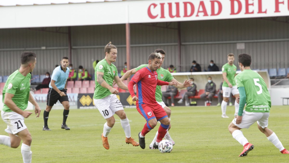 Menudo rodeado de varios jugadores del Haro en el partido de ayer celebrado en la Ciudad Deportiva. LUIS ÁNGEL TEJEDOR
