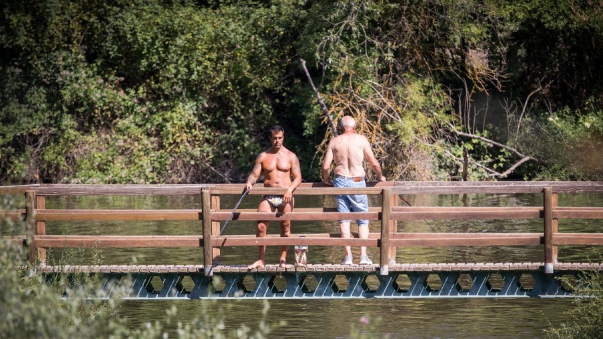 Dos pescadores ligeros de ropa en el Duero durante una ola de calor del pasado año. GONZALO MONTESEGURO