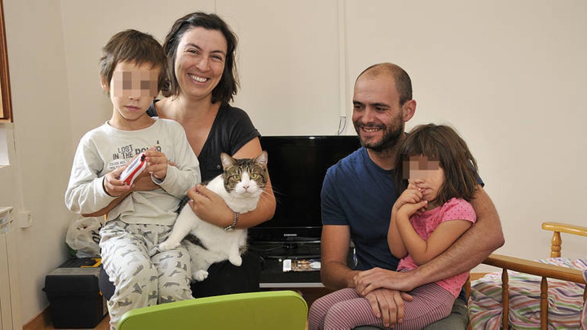 María Llull y Jorge Piña en el salón de su nueva casa junto con sus hijos, Nico y Alba y su gato ‘Tomás’. / VALENTÍN GUISANDE-
