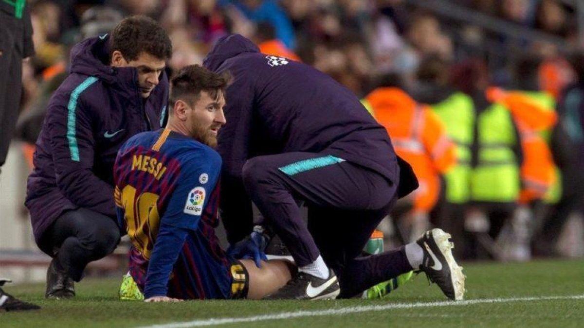 Messi recibe un masaje en el muslo derecho tras quejarse de unas molestias en la segunda mitad del Barça-Valencia.-QUIQUE GARCÍA (EFE)