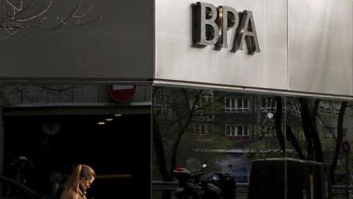 Una joven pasa por delante de una oficina de Banca Privada d'Andorra, en Andorra la Vella.-REUTERS / ALBERT GEA