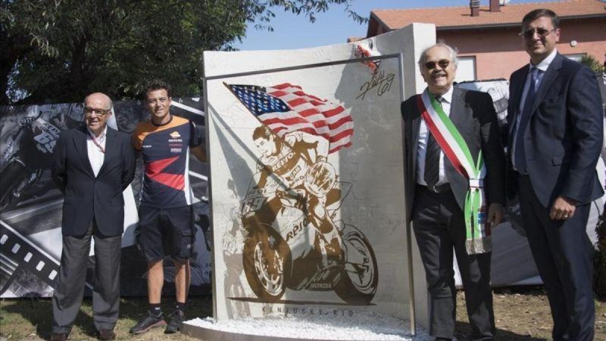 Carmelo Ezpeleta y Denis Pazzaglini, a la izquierda, en la inauguración, hoy, del monumento en recuerdo del desaparecido campeón norteamericano Nicky Hayden.-