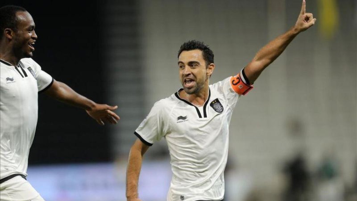 Xavi Hernández no desaprovechó la oportunidad de pasar un rato con sus excompañeros en Doha.-AFP PHOTO