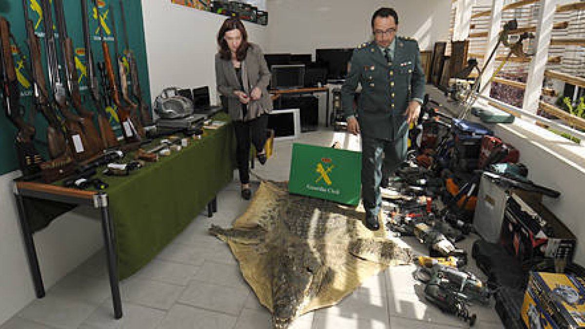 Heredia y Velarde en una de las dependencias llenas de objetos recuperados, con las armas de fuego a la derecha de la imagen. / VALENTÍN GUISANDE-