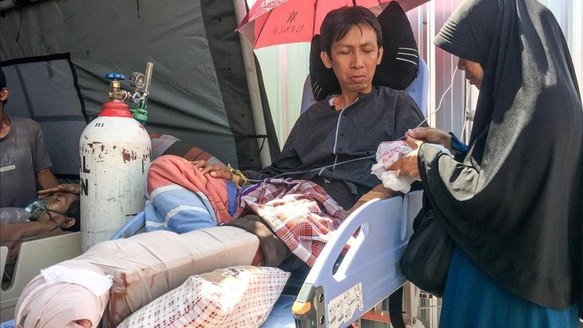 Una mujer atiende a su marido, herido en el terremoto de Lombok, en el hospital de Mataram. /-KIKI SIREGAR (AFP)