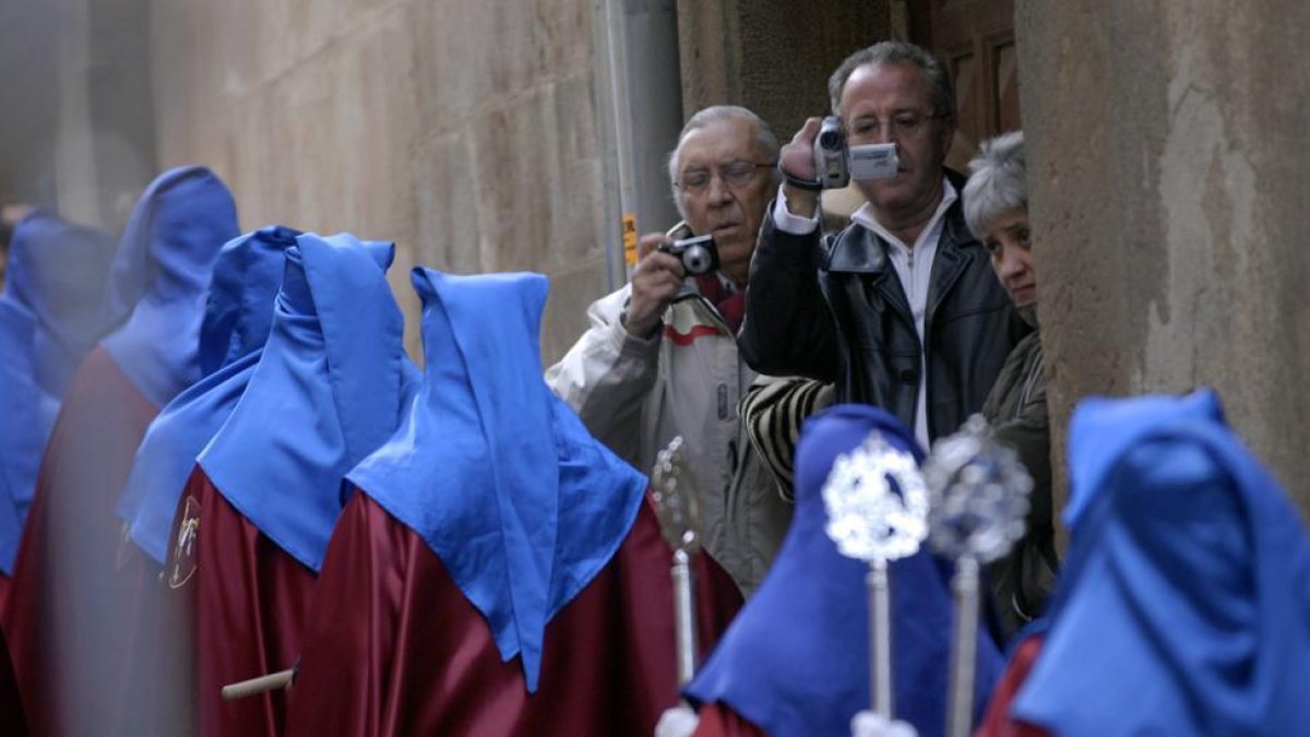 Dos hombres toman imágenes de una procesión.-VALENTÍN GUISANDE