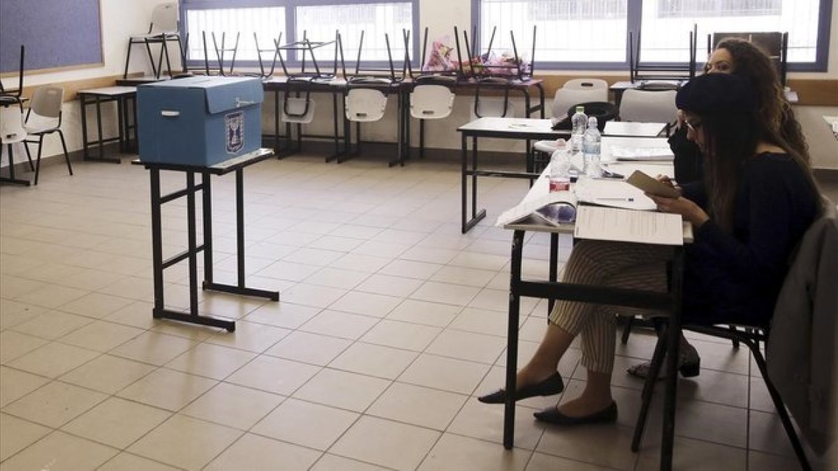 Miembros de una mesa electoral esperan la llegada de votantes en un colegio del este de Jerusalén.-MAHMOUD ILLEAN (AP)