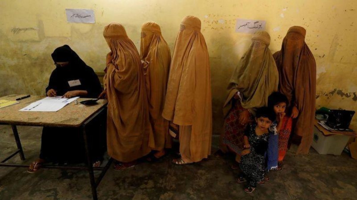 Mujeres ataviadas con burkas votan en un colegio electoral en Peshawar.-FAYAZ AZIZ / EFE